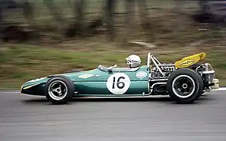 A mid-engined single-seater racing car with modest aerodynamic wings