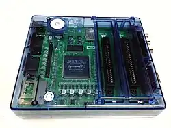 A circuit board and microprocessor in a translucent blue case, with cartridge ports on the right hand side.