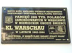 Commemorative plaque placed in 2017, which follows Trzcińska's hypothesis of the camp's history. The plaque reads: "We consecrate the white blot of history that was being hidden [from us] to Our Lady, the Queen of Polish martyrs: In homage to the 200,000 Poles murdered in Warsaw in the German extermination camp KL WARSCHAU in 1942-1944. The camp existed 'in the framework of the annihilation of the Capital of Poland' – from the Sejm resolution dated 27 July 2001 on the victims of KL Warschau. Compatriots – 2017" To the right, a scheme of Warsaw appears with the caption "Pabst Plan – 1940 – Plan of Warsaw's destruction".