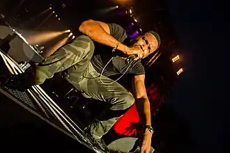 Assassin sitting on stage as he performs in 2014