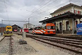 Orange and white electric railcar at a station platform