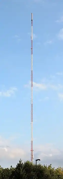 A red-and-white striped TV tower reaching tall into the sky