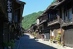 Small street lined by wooden two-storeyed houses.