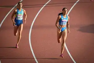 Photo of two athletes on red athletics tracks