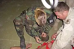 Image 6US Military Police officer restraining and sedating prisoner while a soldier holds him down (from Political corruption)
