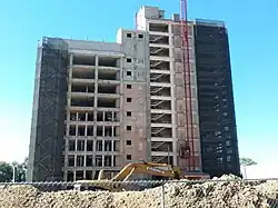 The Ziock building without windows under renovations, with scaffolding and construction on the side of the building