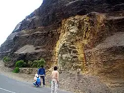 Cross-cutting relationships involving an andesitic dike in Peru that cuts across the lower sedimentary strata. Both the dike and the lower strata are cut by an unconformity