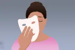 With tears running down her face, the woman with dark skin and hair put on a white mask.