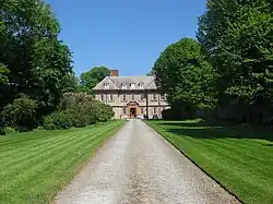 A driveway leading through a park to a mansion