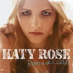 A blonde woman in a tan shirt tugging on her hair with both hands. The text "Katy Rose" and "Because I Can" stand in the center.