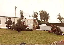 A Permanent Staff Instructor (PSI) with senior Non-Commissioned Officers of the Bermuda Regiment.