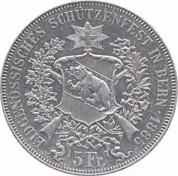 Coat of arms of Bern superimposed over crossed rifles and wreaths. Swiss cross above. Legend and date along edge, denomination below.