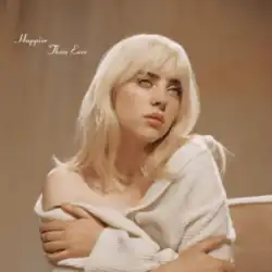 Cover art for 'Happier Than Ever': Billie Eilish with blonde hair and a white off-the-shoulder jacket, hugging herself, while tears fall from her right eye. Behind her is a backdrop colored brown.