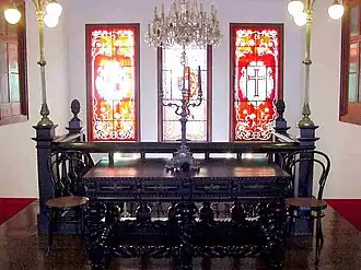 Furniture on the second floor landing, showing the stained-glass windows above the staircase