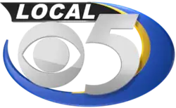 A silver CBS eye and numeral 5. Behind them is a blue-and-yellow swoosh starting from the left and swooping around the bottom and right to the top. The word "Local" is in silver on a black shape in the upper left.