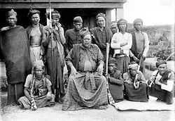 Seated raja, surrounded by other men