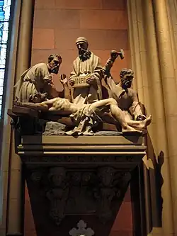 Small stone statuary, mounted on a wall, depicting the crucifixion of Jesus in the Cathedral of the Immaculate Conception