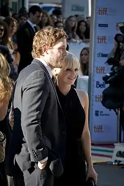 Chris Pratt in a dark gray suit standing next to Anna Faris, who is wearing a black dress