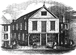 A black-and-white engraving depicting a street scene with a 2.5-story church with mullioned windows at center.