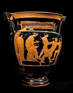 A red figure Column Krater showing Talos falling backwards into the arms of Castor and Pollux while a crouching male figure tampers with a small nail-like circle on Talos' ankle.
