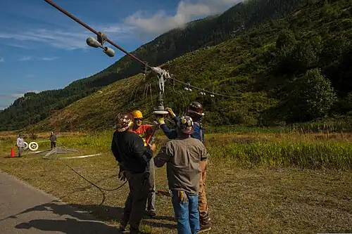 Contractors repairing one of the 1.6 km (1 mile) long antenna wires that span the valley, which here is lowered to the ground for access.
