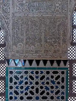 Details of decoration in the main hall: carved stucco above and zellij tiles below