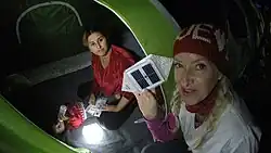 Full-time volunteer, Dr. Alison Thompson is handing a Syrian family a solar lantern called SolarPuff to light their dark tent at the Idomeni refugee camp in Greece. 2015