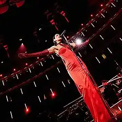 Dua Lipa performing in a red dress.