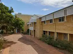This is an image of a pathway surrounded by limestone buildings on the Joondalup campus.