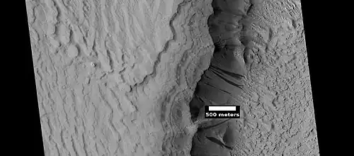 Layers in Gordii Dorsum Region, as seen by HiRISE under HiWish program. Dark lines are Dark Slope Streaks.