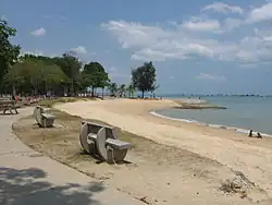 "Headland groyne" at East Coast Beach in Singapore consists of breakwater parallel to shore and connected to shore by a vertical groyne. Higher mainland is fortified with a low rise mud seawall which has been further stabilized by planting grass and trees.