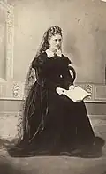 Fredrikke Nielsen with a book on her knees. Oslo Museum TM.T01696.