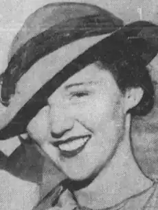 A smiling young white woman, wearing a brimmed hat