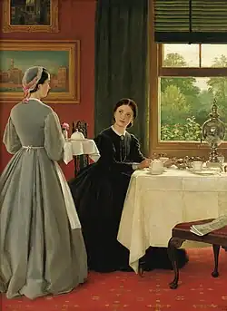 Maid serving tea to a seated woman