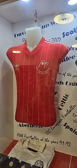 a red Aberdeen football shirt in a display cabinet