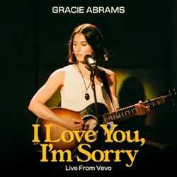 A woman plays the acoustic guitar in front of a microphone. In the top center, a name reads: "Gracie Abrams". In the bottom center, in big letters, it reads the title: "I Love You, I'm Sorry", and below, in small letters, it read: "Live From Vevo"