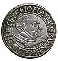 A silver coin showing the head of a bearded man, surrounded by the text 'Iohan DG Mar Branden et Ste'
