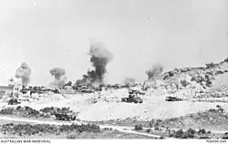 A black and white photograph of smoke rising after a bombing