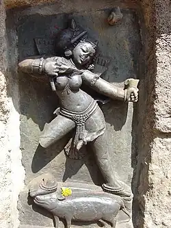 One of the Yoginis of Chausathi Yogini Temple at Hirapur, Odisha. There is an offering of flowers at the yogini's feet.