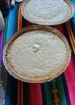 A cheesecake set on a table to cool down after it was finished baking.