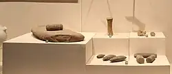 Houli culture grinding slab and handstone, stone axes. Jinan Museum.