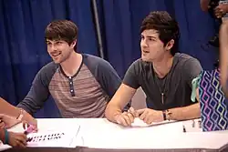 Ian Hecox to the left and Anthony Padilla to the right at VidCon 2014, sitting down while signing autographs