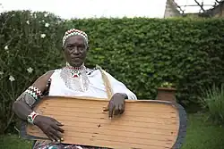 Photo of a trough zither called an Inanga, and its player Torobeka Joseph from Burundi.