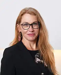 Ingrid Kressel Vinciguerra wearing a black coat with her black glasses and having brown hair