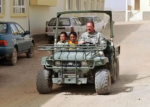 U.S. soldier gives two Hazara boys a ride in Jaghori, Ghazni
