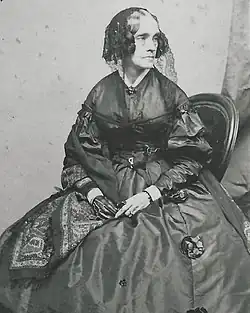 Black-and-white portrait of Pierce, age fifty, wearing a dark dress, hat with veil, and glove on her right hand