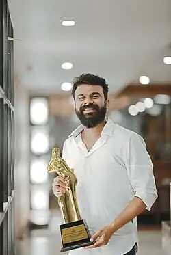 Varghese holding the Kerala State Award for Best Music Director (2021)