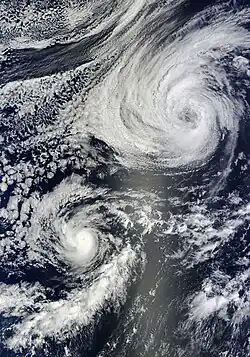 A photograph of two tropical cyclones near each other over the Eastern Pacific Ocean; one is a hurricane and the other is a tropical storm