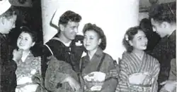 Three Allied servicemen talk to three Japanese women with varying looks of discomfort.