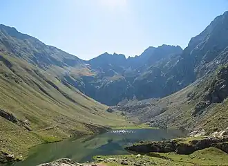 A body of water surrounded by green mountains.